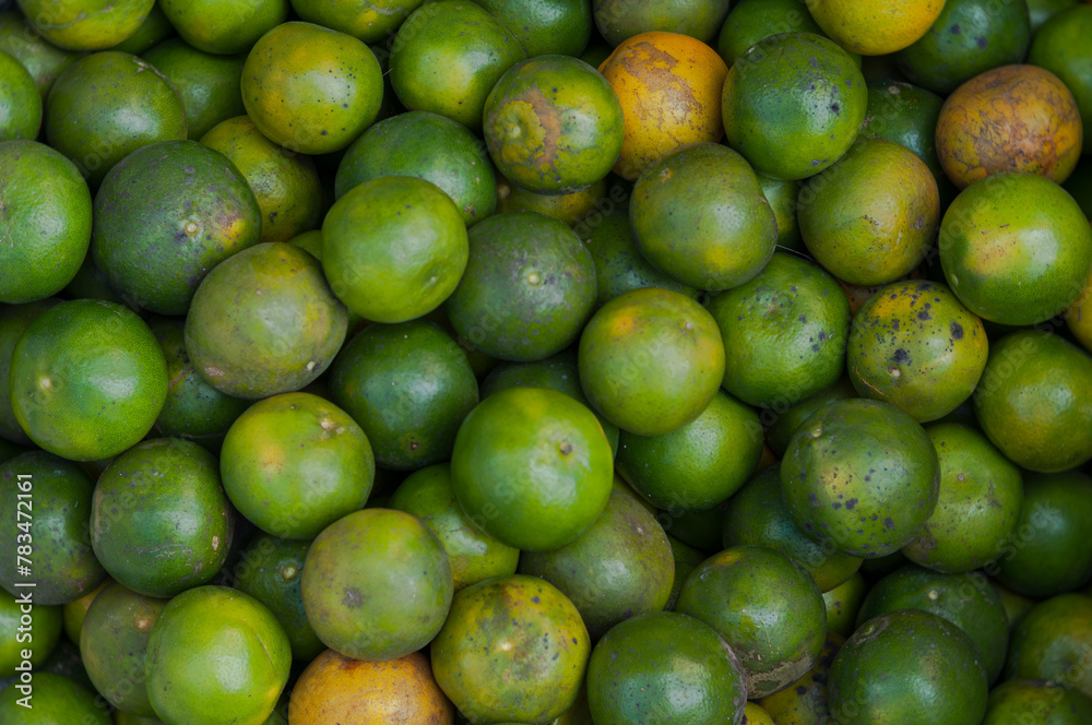 Fresh green bitter oranges fill the frame, showcasing healthy fruits at a local market. Fresh green bitter oranges fill the frame, showcasing healthy fruits at a local market.