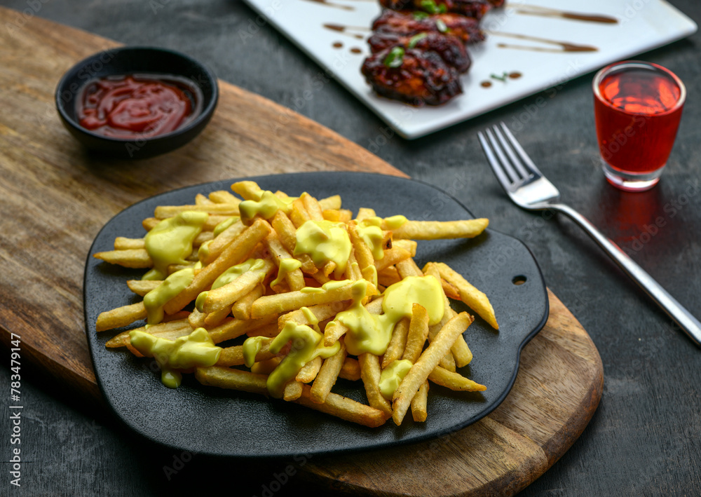 French fries with cheese, sauce and fork French fries with cheese, sauce and fork