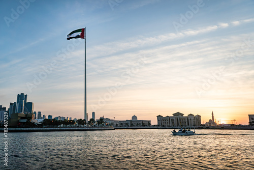 A flag on the background of beautiful tall skyscrapers at sunset. Cityscape of Flag Island, Sharjah.