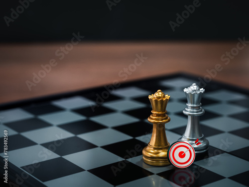 3d target icon with golden and silver queen chess pieces standing together on a chessboard on dark background. Leader, team, collaboration, cooperation, partnership, and business strategy concept.