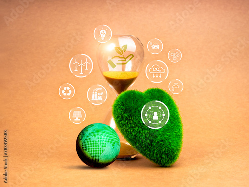 Green life sustainability, environment responsibility concept. Last chance for restoring the earth. Renewable icons on 3d earth globe, green grass heart shaped and hourglass on brown background.