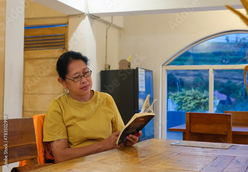 A woman is reading a book in a small library photo