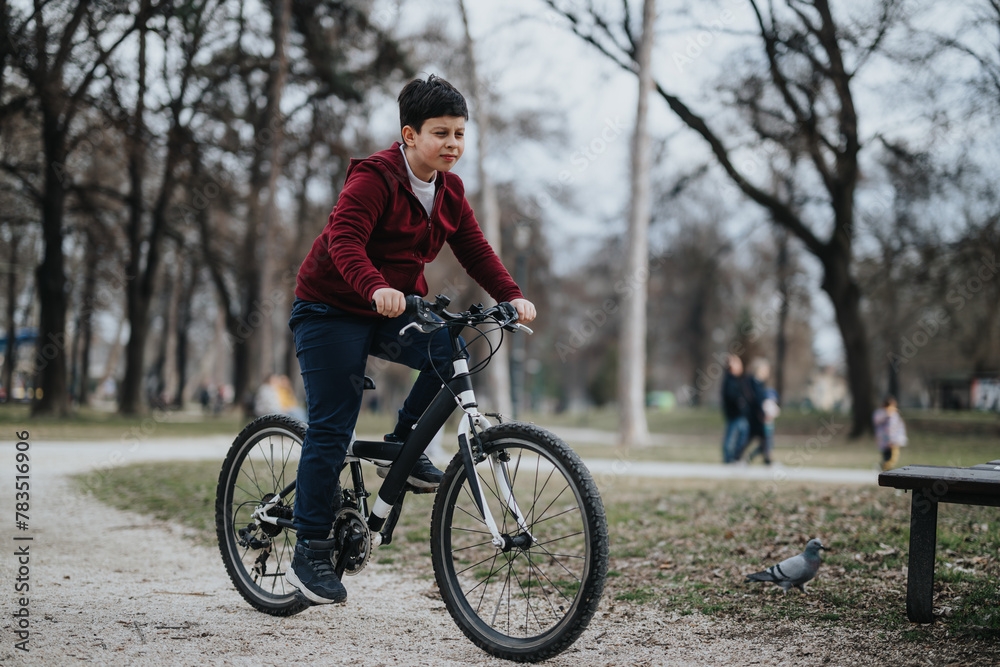 A youthful boy is captured riding his bicycle through a city park, a picture of healthy outdoor activity and carefree childhood joy. A youthful boy is captured riding his bicycle through a city park, a picture of healthy outdoor activity and carefree childhood joy.