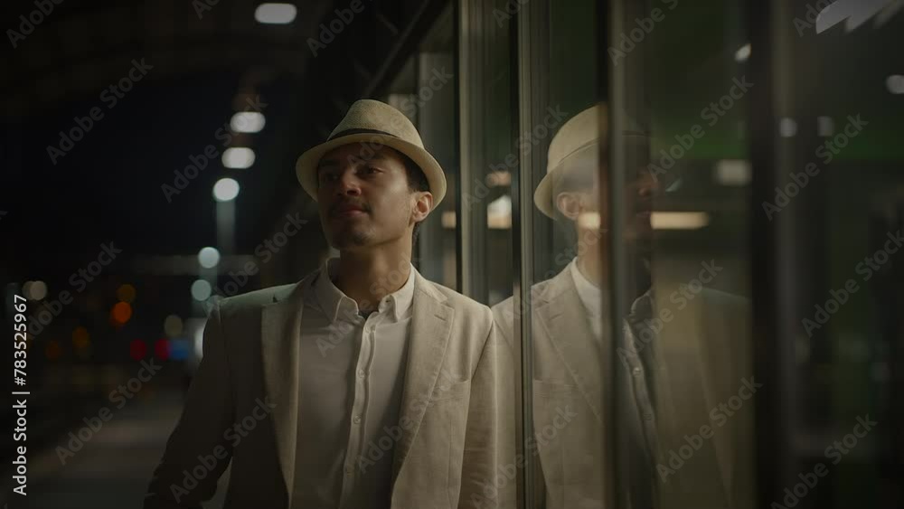Young Man Waiting Alone at Train Station Platform at Night