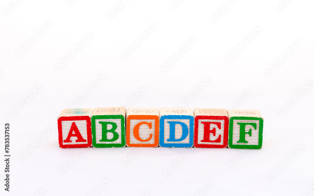 Closeup wooden letter toy arranged the word ABCDEF in a row isolated on white background Closeup wooden letter toy arranged the word ABCDEF in a row isolated on white background
