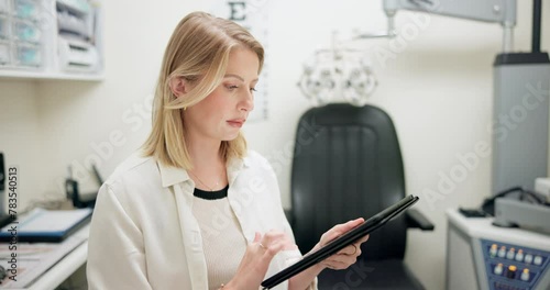 Tablet, ophthalmology and woman optician in store for eye exam with vision, eye care or health. Research, optometry and female optometrist typing information on digital technology in optical shop. photo
