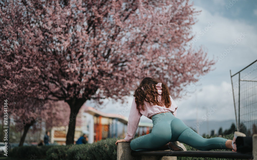 Rear view of a relaxed woman sitting beneath blooming cherry trees, representing tranquility and spring. Rear view of a relaxed woman sitting beneath blooming cherry trees, representing tranquility and spring.