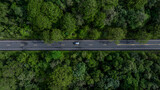 Aerial view electric vehicle car or EV car on green forest road, EV car travel in green season, Asphalt road and green forest, Forest road going through forest with electric car.