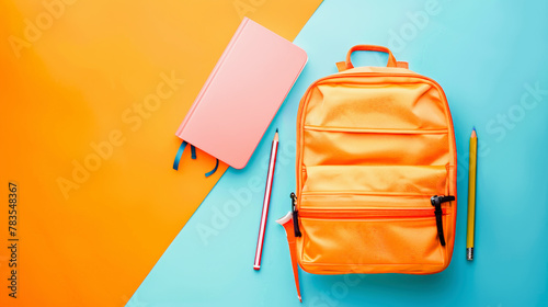 Back-to-school supplies featuring a pink notebook and an orange backpack with pencils on a dual blue and orange background. photo