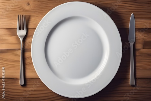 An empty plate and fork on a wooden table  viewed from above  with a pristine white plate and a textured warm oak table.