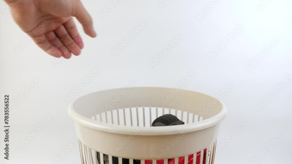 A broken children's toy car is thrown into the garbage can. Recycling of plastics.