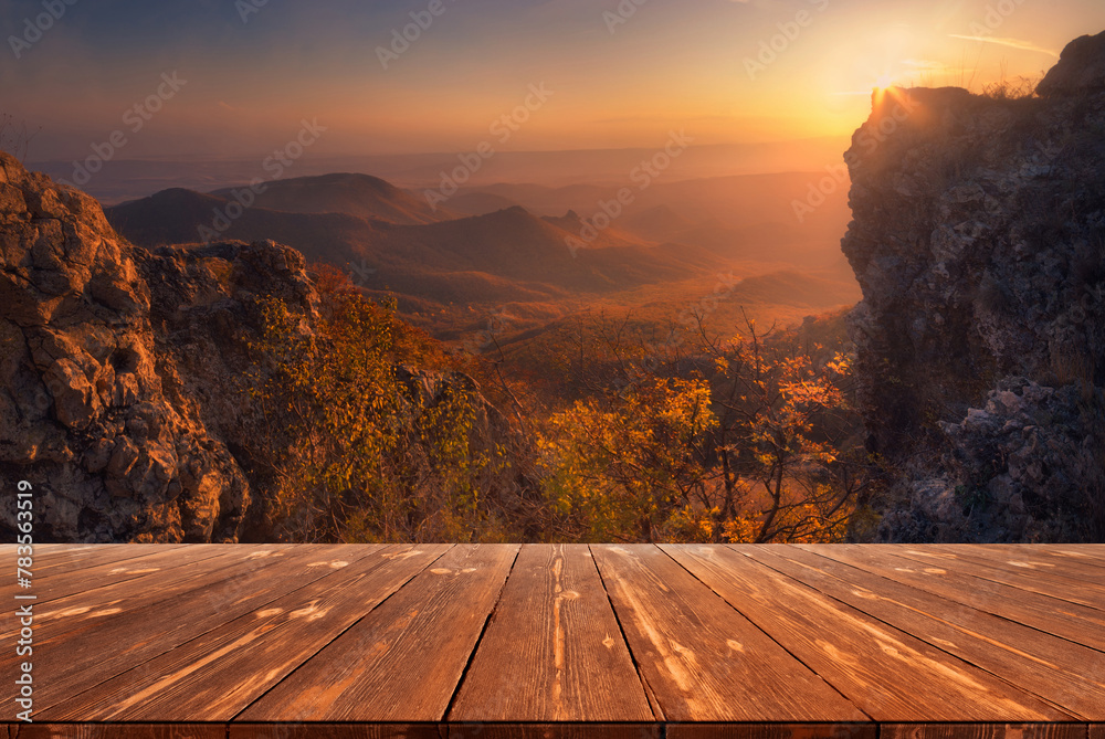 Summer beautiful background with sunset over mountains and empty wooden table in nature outdoor. Natural template landscape