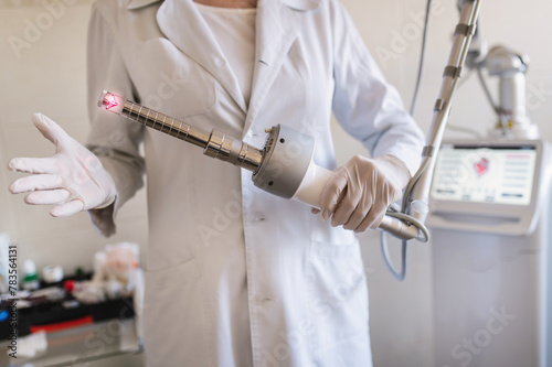 female doctor holds in her hands a carbon dioxide laser with a phallic attachment for vaginal rejuvenation. Hardware cosmetology and medicine. Skin tightening, scar removal, stretch marks and lifting 
