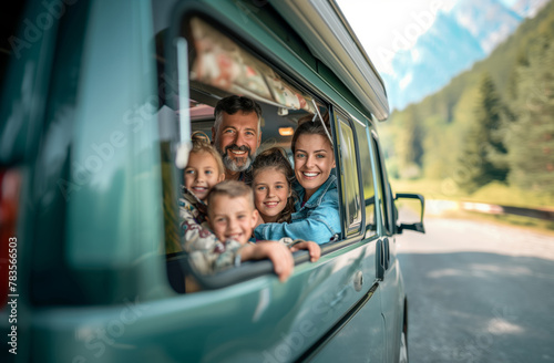 Multi-generation family looking at camera outdoors at dusk, caravan holiday trip photo