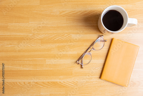 机の上のコーヒーとノートと眼鏡