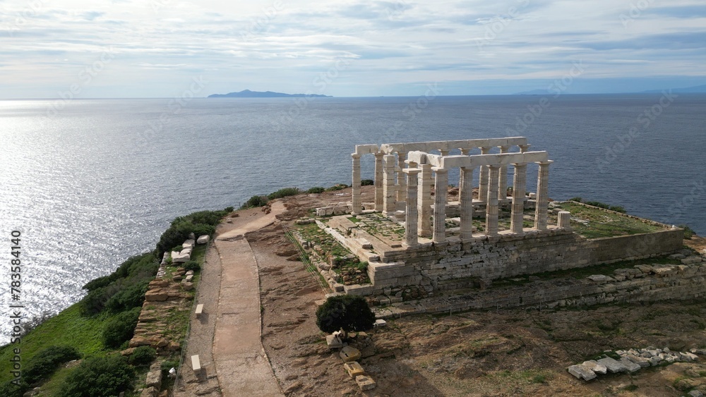 Temple of Poseidon is one of the most famous monuments in Greece , perched on a rocky promontory overlooking the Egean Mediterranean  sea , Cape Sounion - drone aerial view of Unesco Heritage world 