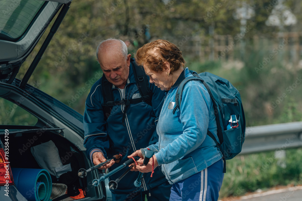 senior couple equipping themselves in the car for hiking