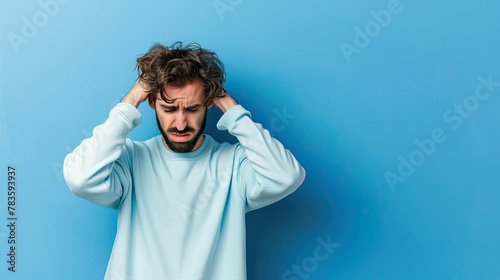 Man feeling anxious and tormented on pastel blue background