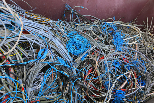 quantity of used electrical wires in the recycling container for the recycling of material and copper to safeguard the environment photo