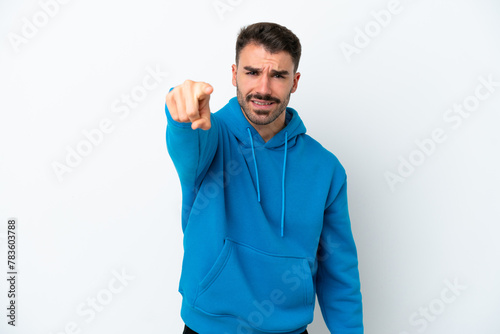 Young caucasian man isolated on white background frustrated and pointing to the front © luismolinero