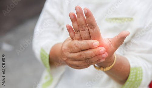 close up senior woman massage on fingers to relief pain from hard working for treatment about gout and rheumatoid symptoms and chronic illness health care concept