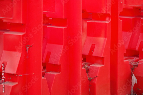 Partial view of red plastic road traffic barrier blocks on a roadsid