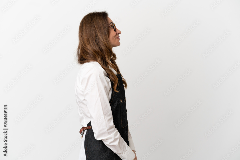 Restaurant middle aged waiter woman isolated on white background laughing in lateral position Restaurant middle aged waiter woman isolated on white background laughing in lateral position