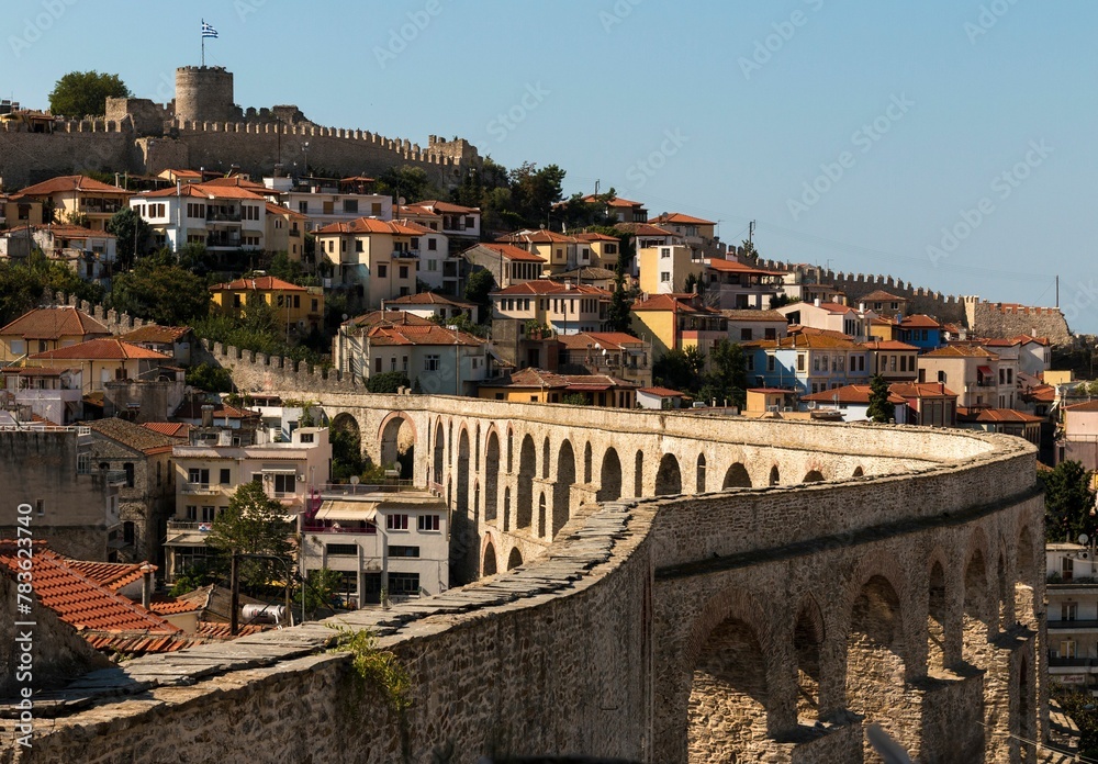 Obraz premium Beautiful view of city of Kavala in Greece with the Greek flag on the castle and old urban buildings