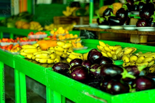 Eggplants and banana on green display in the market