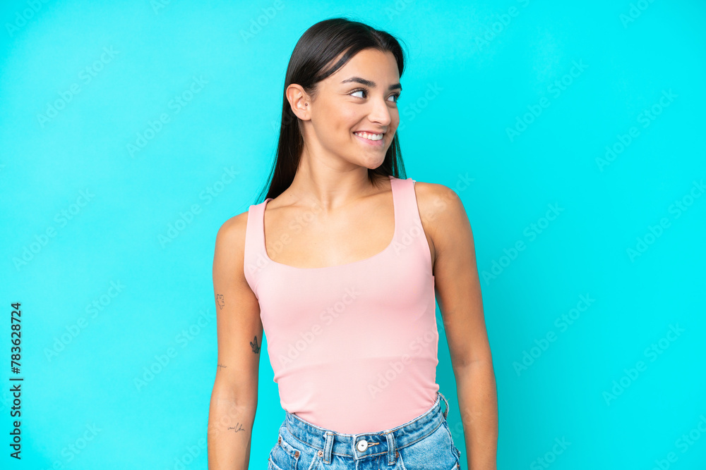 Young caucasian woman isolated on blue background looking side Young caucasian woman isolated on blue background looking side
