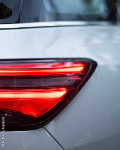 Vertical closeup of a white car's headlight © Wirestock