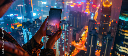 Woman use smartphone to take photo of night cityscape with city lights.  © Pixelmagic