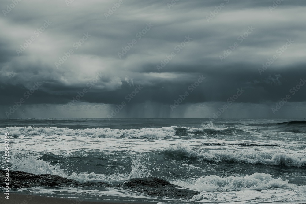 Mesmerizing view of the splashing waves of the ocean with dark clouds in the sky
