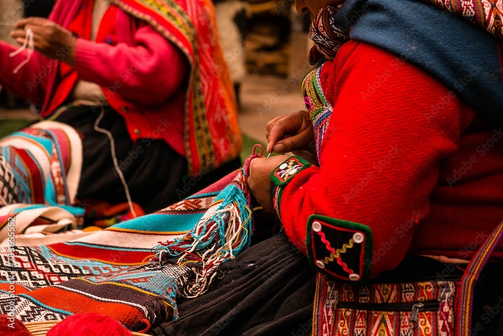 Closeup shot of Peruvian women working on beautiful handmade textiles