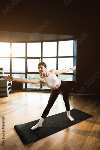 Young athletic woman is engaged in fitness and does yoga in the gym.Yoga and fitness.Healthy lifestyle concept