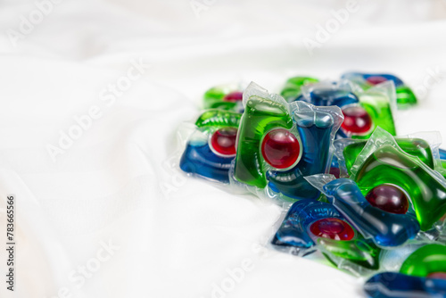 Lots of laundry pods capsule detergent on satin fabric, copy space for text.