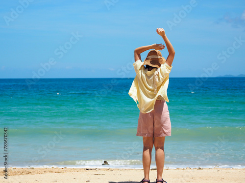 Beautiful Asian woman wearing a straw hat on the sea beach