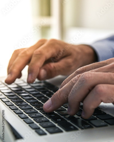 Closeup man hands typing on computer keyboard. Businessman using laptop at home. Office workplace
