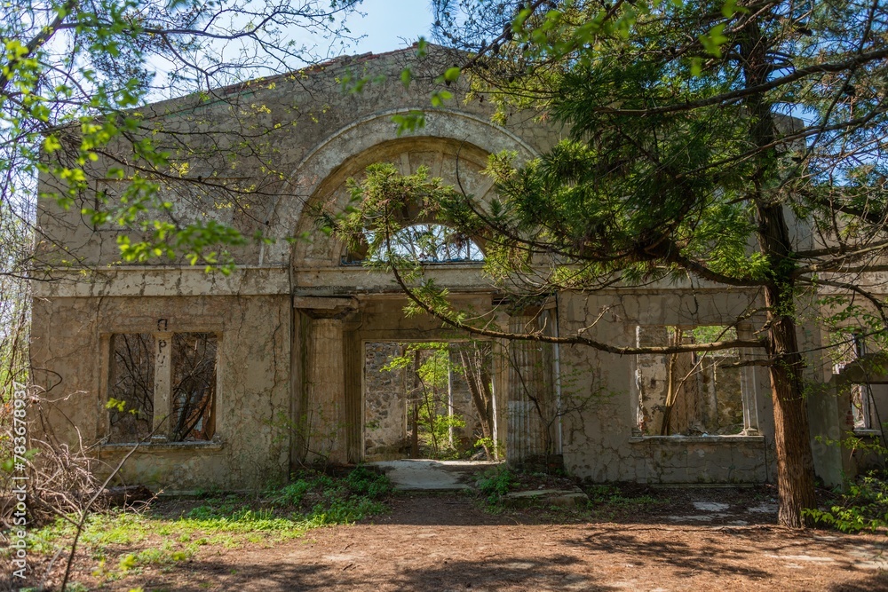 facade of an old abandoned dilapidated villa surrounded by the first spring bright green foliage in an abandoned park on the Black Sea coast on a sunny day in April facade of an old abandoned dilapidated villa surrounded by the first spring bright green foliage in an abandoned park on the Black Sea coast on a sunny day in April