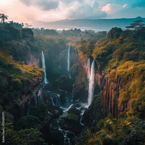 Breathtaking aerial view of a tropical waterfall surrounded by lush forest and cliffs  with mist rising from the cascading water.