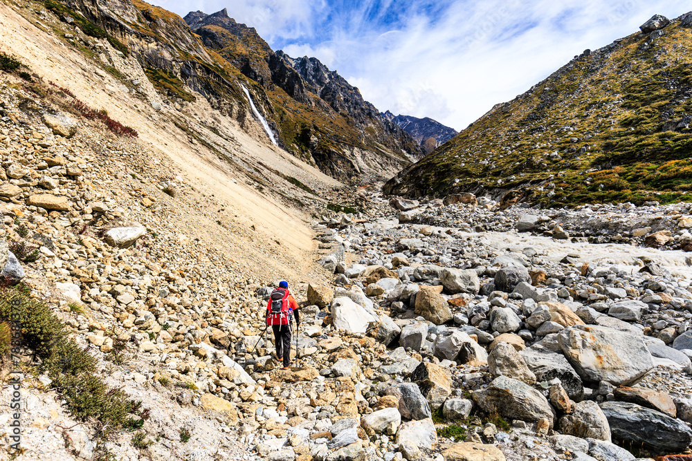 Sherpa guide is crossing a dangerous landslide section on the Kanchenjunga Base Camp Trek between Khambachen (aka Khangpachen or Kambachen) and Lhonak in the Himalaya Mountains, Nepal