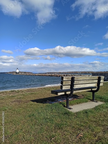 bench on the beach and lighthouse on the background