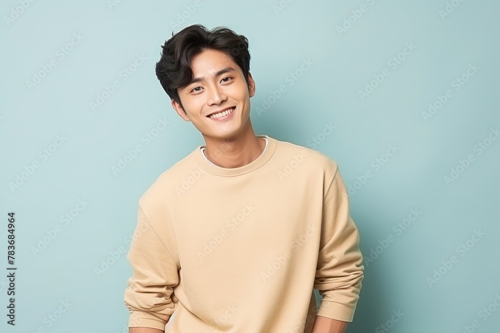 A young man is smiling and wearing a tan shirt A young man is smiling and wearing a tan shirt