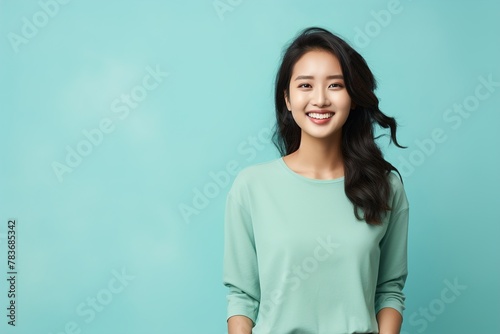 A woman with long hair is smiling and wearing a green shirt
