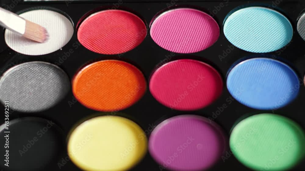 close-up face painting palette with different colors. using a brush to paint the makeup on the face. box with makeup paints and brush close-up face painting palette with different colors. using a brush to paint the makeup on the face. box with makeup paints and brush