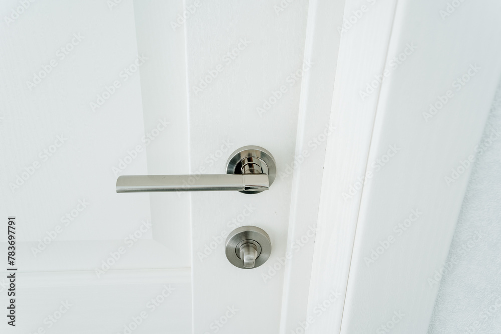 Shiny Metal Door Handle On White Door, Handle Set With Lock, Interior Trim Hardware In Room. Shiny Metal Door Handle On White Door, Handle Set With Lock, Interior Trim Hardware In Room.