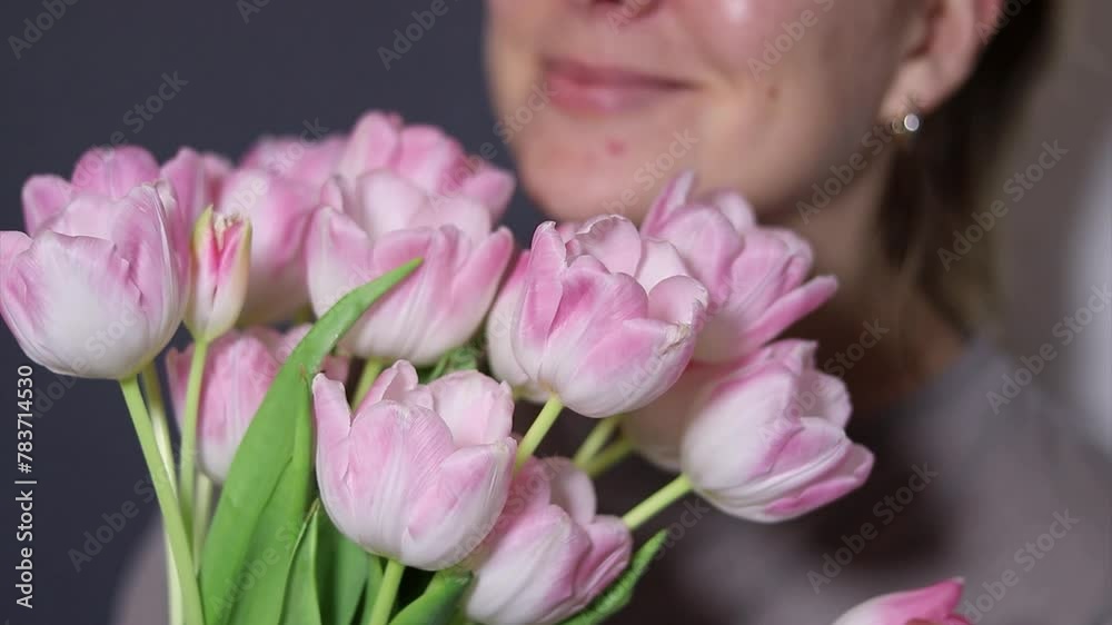 Close up of pink tulip flower bouquet, blurry background with a happy smiling woman Close up of pink tulip flower bouquet, blurry background with a happy smiling woman