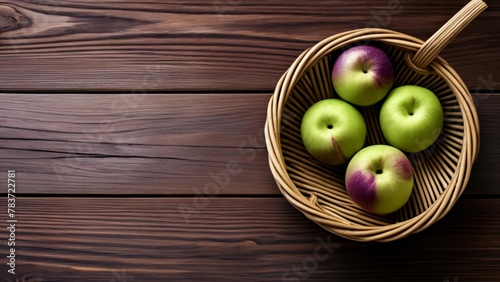  Fresh apples in a woven basket on a wooden surface © vivekFx