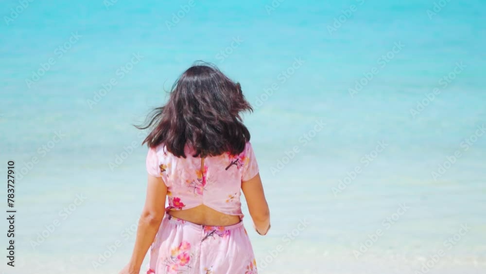 Young Indian woman running towards ocean in pink dress at Agatti island, Lakshadweep, India. Summer vacation beach relaxation concept. Wild, Free, Beauty, Feminine Energy. Young Indian woman running towards ocean in pink dress at Agatti island, Lakshadweep, India. Summer vacation beach relaxation concept. Wild, Free, Beauty, Feminine Energy.