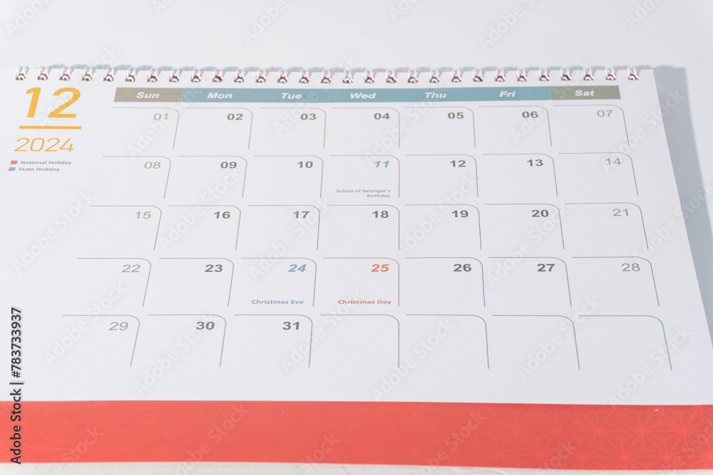 December calendar of 2024 displaying on white background. Desk calendar side view and selective focus shot for concept. 